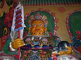 Tibet 06 03 Gyantse Pelkor Chode Vaishravana Guardian of the North The Pelkor Ch�de, built between 1418 and 1425, is an imposing severe building that houses superb works of art. Only four buildings remain: the three-storey main chanting hall, the Kumbum, a dormitory for the monks, and the thangka wall. The entrance to Pelkor Ch�de has modern statues of the four guardian Kings. The orange-faced statue is Vaishravana, the guardian of the north, holding a victory banner and a jewel-spitting mongoose. He is also called Jambhala, the Bodhisattva of wealth and abundance.